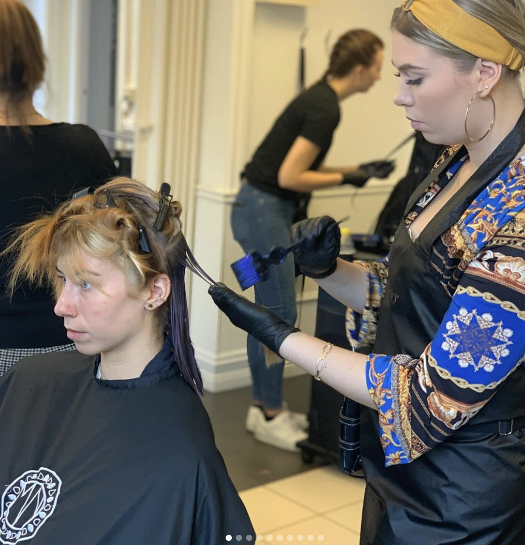 Frisörstudenter praktiserar klippning på sin frisörutbildning Göteborgs Frisörskola